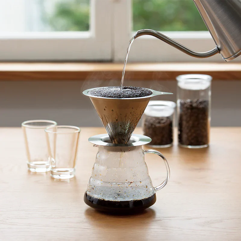 Hario Double Mesh Metal Dripper 02 in use on a wooden table, showcasing stainless steel design and double mesh filter.